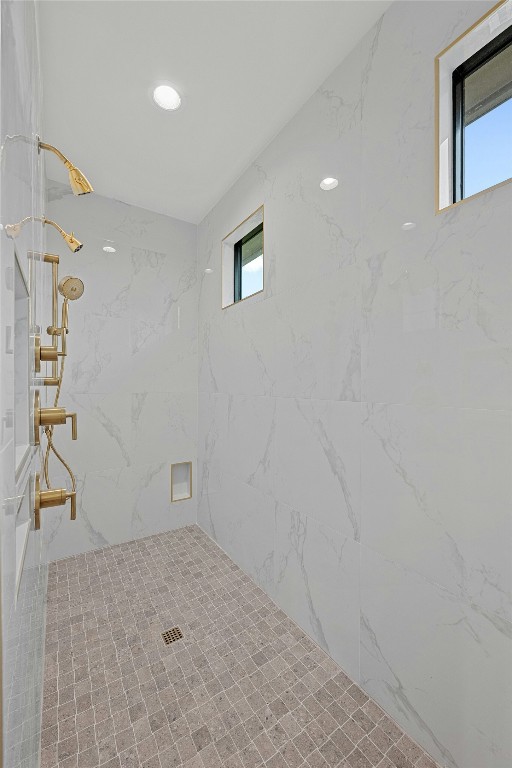 bathroom with a healthy amount of sunlight and a tile shower