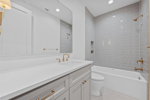 full bathroom with tiled shower / bath, vanity, toilet, and tile patterned floors