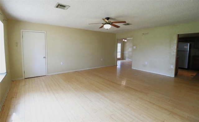 unfurnished room featuring ceiling fan, a textured ceiling, and light hardwood / wood-style flooring