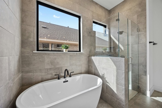 bathroom featuring independent shower and bath and tile walls