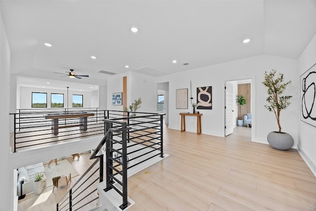 staircase with lofted ceiling, hardwood / wood-style floors, plenty of natural light, and ceiling fan