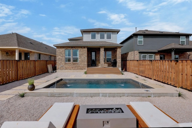 view of pool with a patio area, pool water feature, and an outdoor fire pit