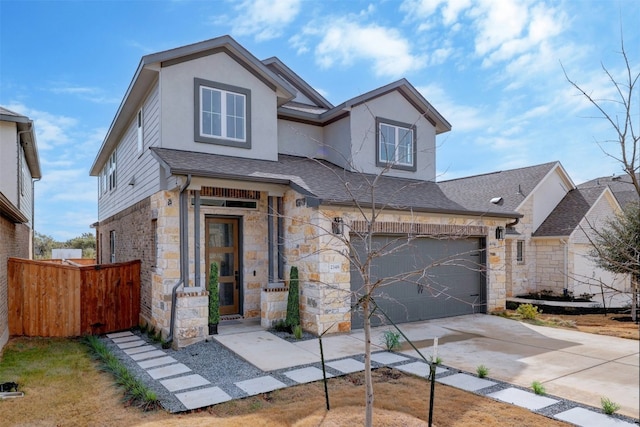 traditional home featuring a garage, concrete driveway, stone siding, fence, and stucco siding