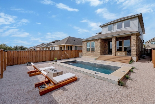 view of swimming pool featuring a fire pit, grilling area, pool water feature, and a patio area