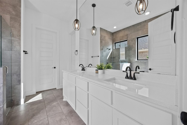 bathroom with visible vents, a sink, and a shower stall