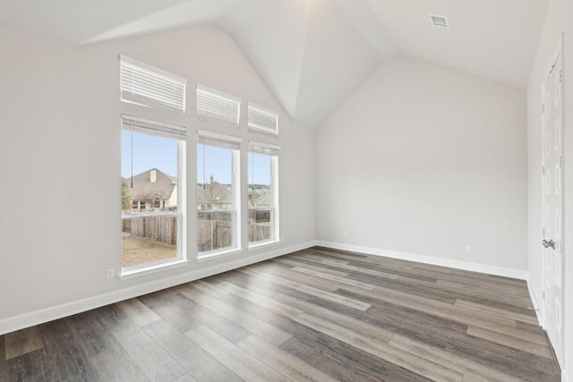 empty room with wood-type flooring and high vaulted ceiling