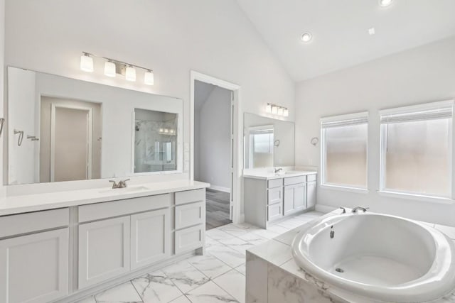 bathroom featuring vanity, high vaulted ceiling, and independent shower and bath