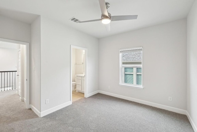 unfurnished bedroom with light carpet, connected bathroom, and ceiling fan