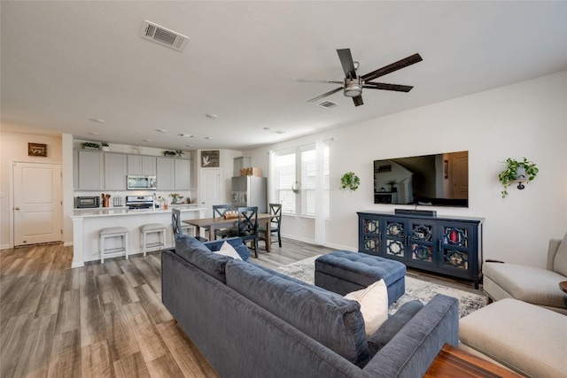 living room with ceiling fan and light wood-type flooring