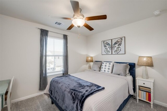 carpeted bedroom with a ceiling fan, visible vents, and baseboards