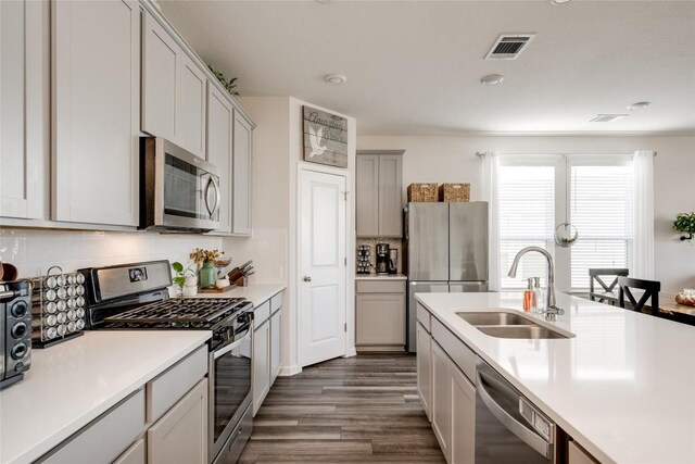 kitchen featuring dark wood finished floors, appliances with stainless steel finishes, light countertops, a sink, and visible vents