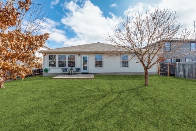 back of property with a yard and a patio area