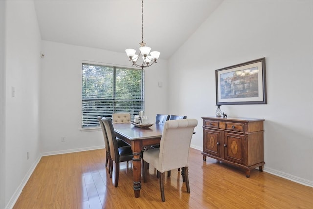 dining space featuring a notable chandelier, vaulted ceiling, and light hardwood / wood-style floors