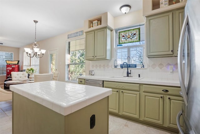 kitchen featuring sink, tile counters, a kitchen island, pendant lighting, and stainless steel appliances