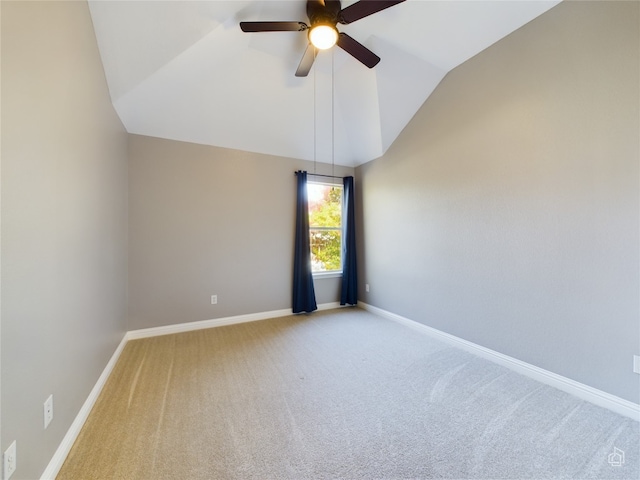 empty room featuring lofted ceiling, carpet floors, and ceiling fan