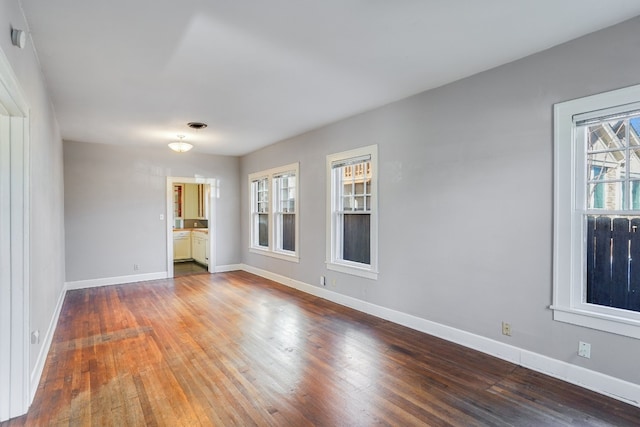 empty room with wood-type flooring and a healthy amount of sunlight