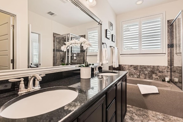 bathroom featuring a washtub, double vanity, visible vents, a stall shower, and a sink