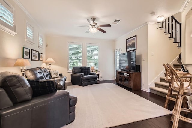 living area with ornamental molding, visible vents, dark wood finished floors, and stairs