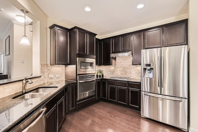 kitchen with sink, hanging light fixtures, stainless steel appliances, light stone countertops, and dark hardwood / wood-style flooring