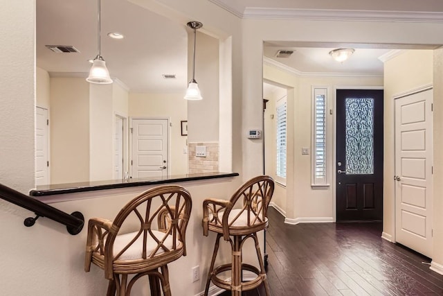 interior space featuring baseboards, visible vents, dark wood finished floors, and crown molding