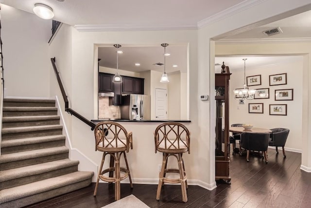 kitchen with dark wood-style floors, visible vents, crown molding, and stainless steel fridge with ice dispenser