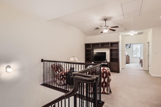 corridor with visible vents, attic access, light carpet, an upstairs landing, and baseboards