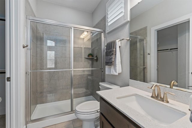 bathroom with vanity, an enclosed shower, tile patterned floors, and toilet