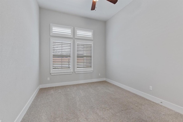 carpeted spare room featuring ceiling fan