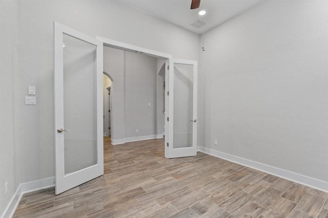 unfurnished bedroom featuring light hardwood / wood-style floors, french doors, and ceiling fan