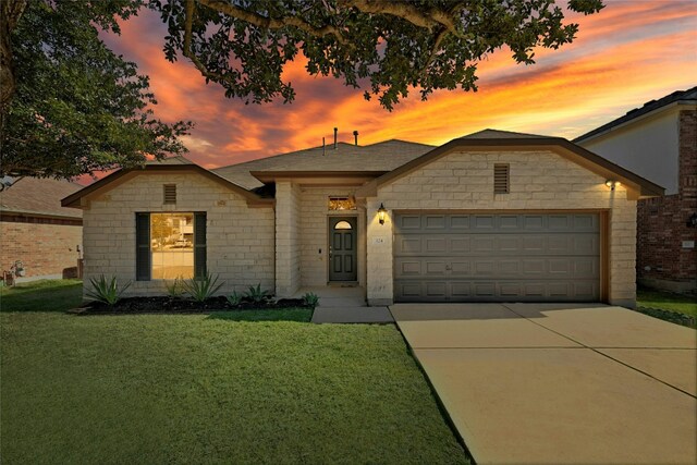 ranch-style house featuring a garage and a yard