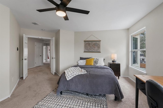 bedroom featuring baseboards, ceiling fan, visible vents, and light colored carpet