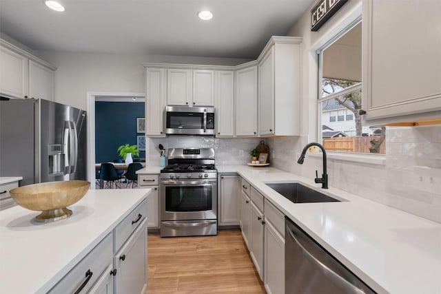 kitchen featuring appliances with stainless steel finishes, light countertops, and a sink