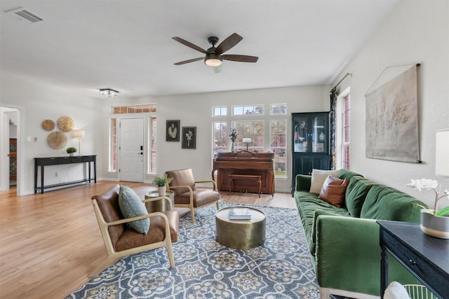 living area featuring wood finished floors, visible vents, and a ceiling fan