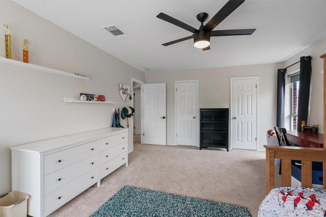 bedroom with light carpet, a ceiling fan, visible vents, and multiple closets