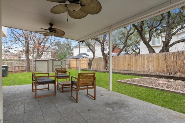 view of patio with ceiling fan, a storage unit, an outdoor structure, and a fenced backyard