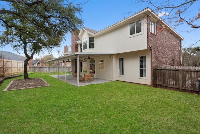 back of house featuring ceiling fan, a fenced backyard, brick siding, a yard, and a patio area