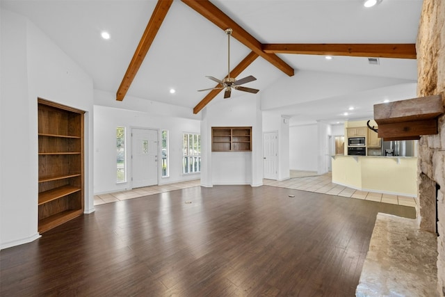 unfurnished living room with built in shelves, high vaulted ceiling, light wood-type flooring, ceiling fan, and beam ceiling