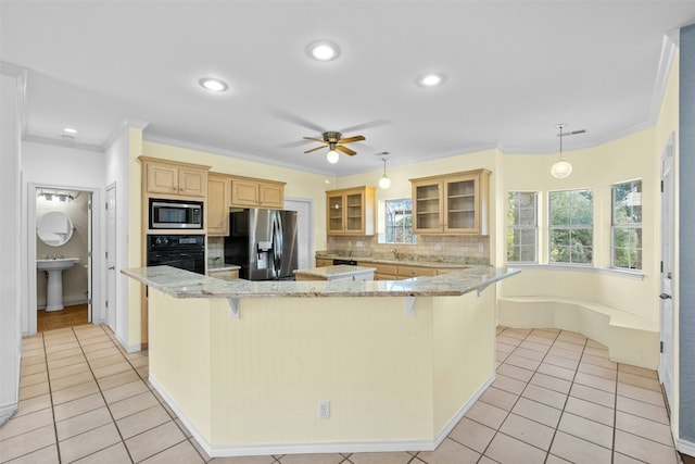 kitchen with appliances with stainless steel finishes, light tile patterned floors, a kitchen bar, and decorative light fixtures