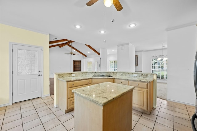 kitchen featuring a center island, light stone counters, light brown cabinetry, and kitchen peninsula