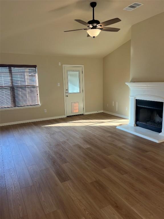 unfurnished living room with hardwood / wood-style flooring, vaulted ceiling, and ceiling fan