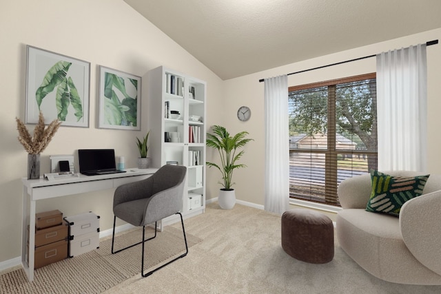 home office with a textured ceiling, lofted ceiling, and light colored carpet