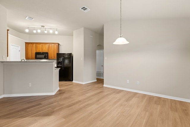 kitchen with light hardwood / wood-style flooring, kitchen peninsula, pendant lighting, and black appliances