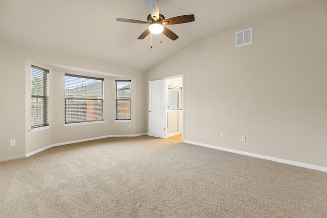 spare room featuring vaulted ceiling, light colored carpet, and ceiling fan