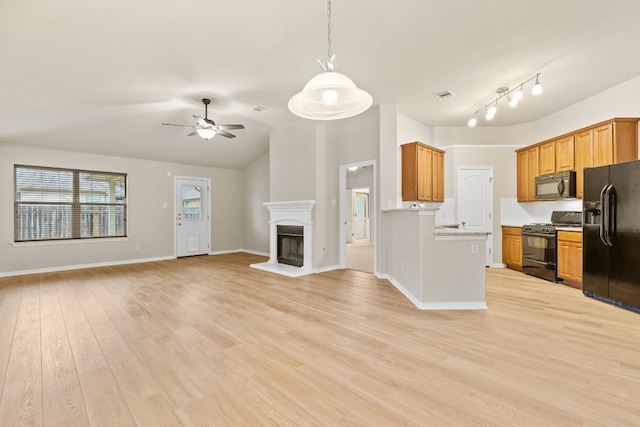 kitchen with hanging light fixtures, black appliances, lofted ceiling, ceiling fan, and light hardwood / wood-style floors