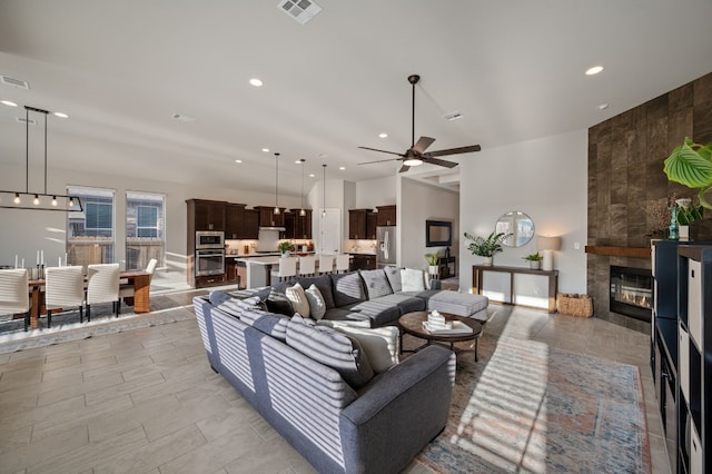 living room featuring a tile fireplace and ceiling fan