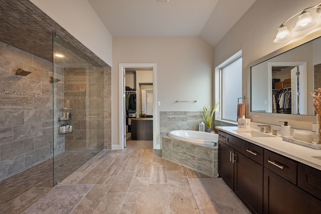 bathroom featuring vanity, lofted ceiling, and shower with separate bathtub