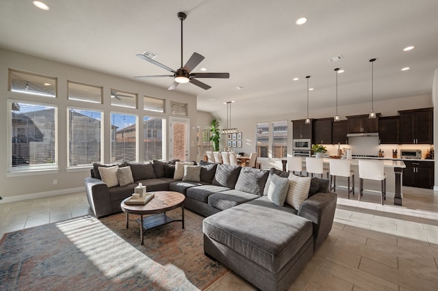 tiled living room with a wealth of natural light and ceiling fan