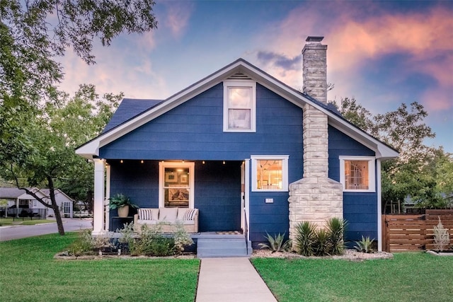 bungalow featuring a yard and covered porch