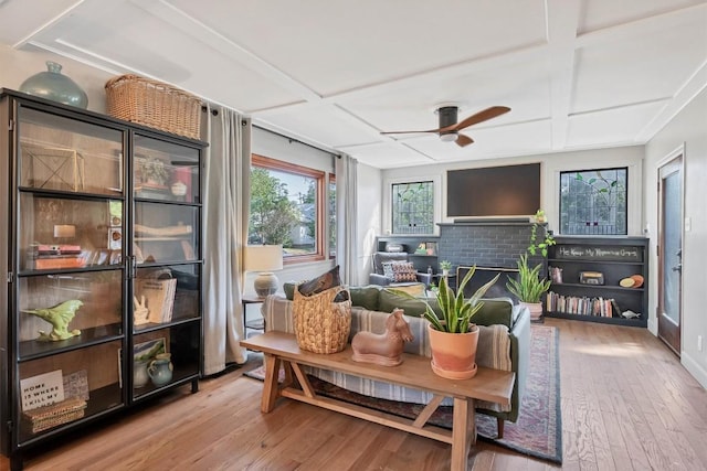 sunroom featuring coffered ceiling, a fireplace, and ceiling fan