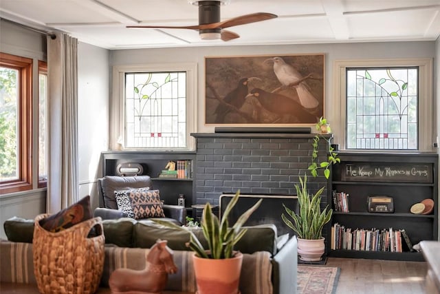 sitting room with ceiling fan, wood-type flooring, coffered ceiling, and a brick fireplace